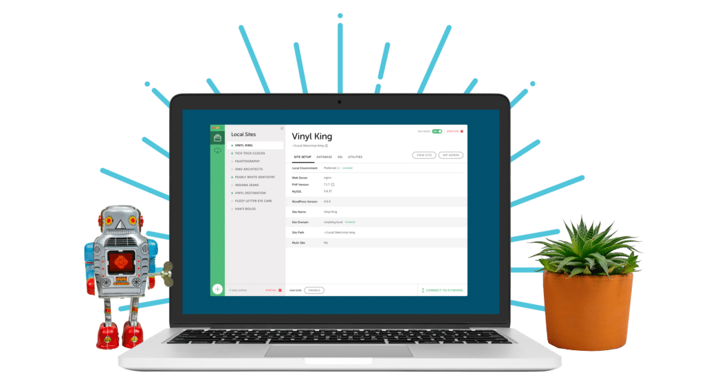 a small robot and a desktop planter flank a laptop screen that's open to Local, the WordPress development tool