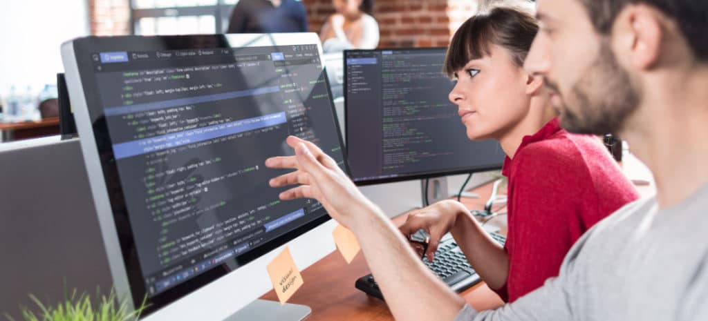 two people looking at code on a computer screen