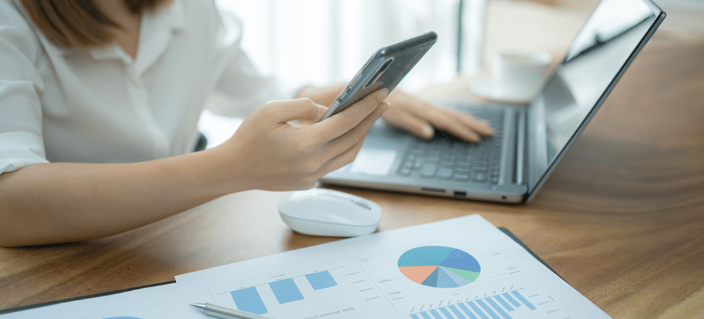 a woman building a landing page checks its design on mobile and laptop views while reviewing the page's analytics